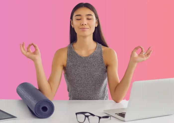 Une femme en posture de yoga devant son ordinateur, symbolisant l’équilibre entre travail et bien-être grâce au droit à la déconnexion.